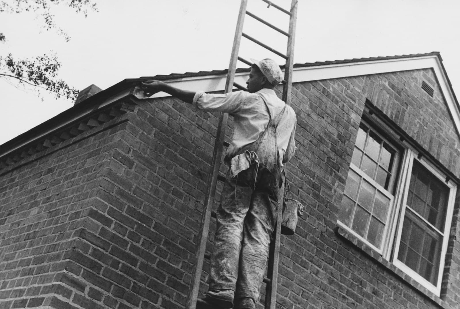 Peintre en bâtiment travaillant sur une façade